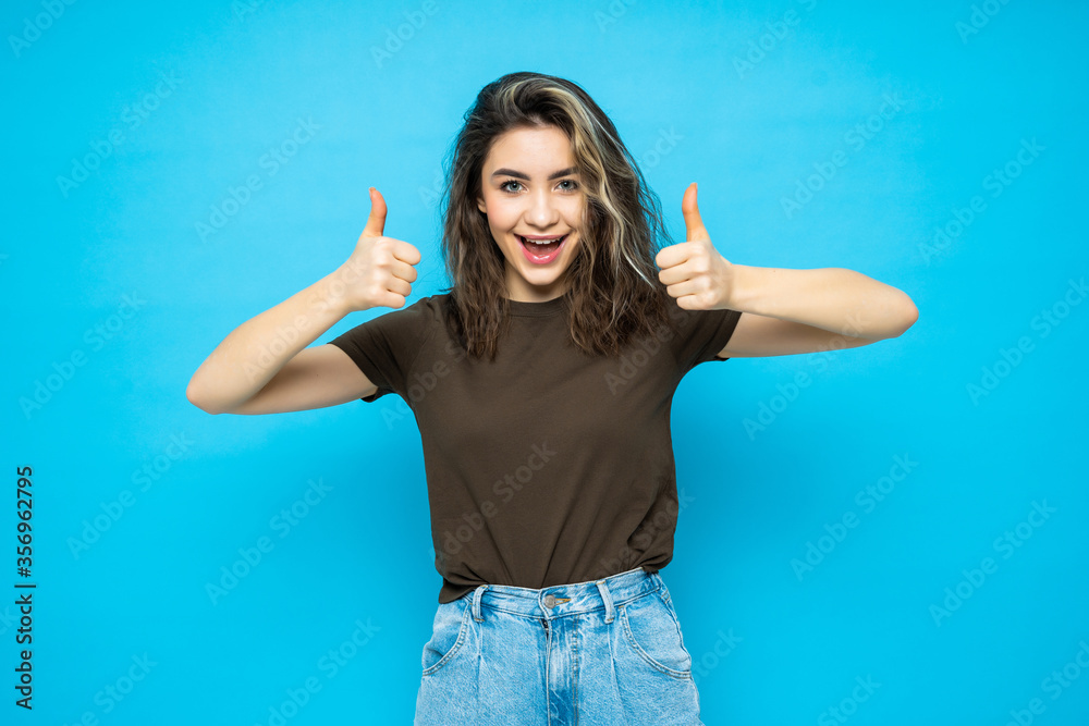 Portrait of beautiful woman with thumbs up on blue background Portrait of beautiful woman with thumbs up on blue background