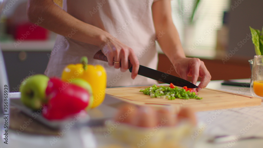 Housewife cutting vegetables at kitchen.Lady eating cherry tomato in slow motion