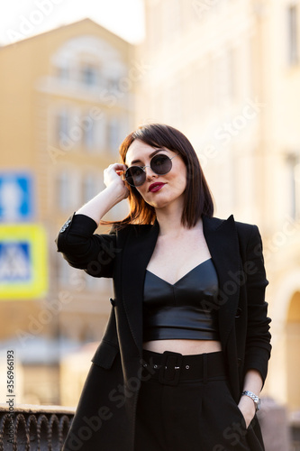 Woman in black pantsuit walks on promenade