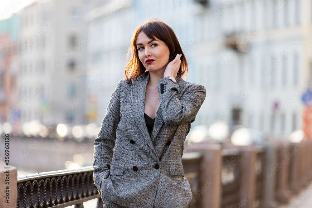 Woman in gray pantsuit walks on promenade Woman in gray pantsuit walks on promenade