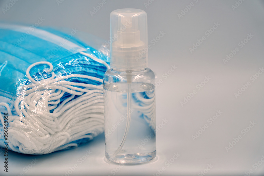 Surgical face mask and hand sanitizer over white background Surgical face mask and hand sanitizer over white background