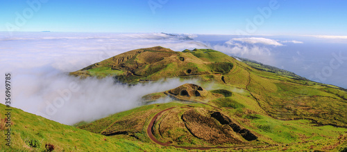 Panoramic view of green landscape above the clouds with grass and ocean at the island of Sao Jorge, Azores, Portugal photo