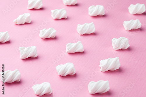 Marshmallows on a pink background Soft pink color mini marshmallows dessert top view, flat lay style.