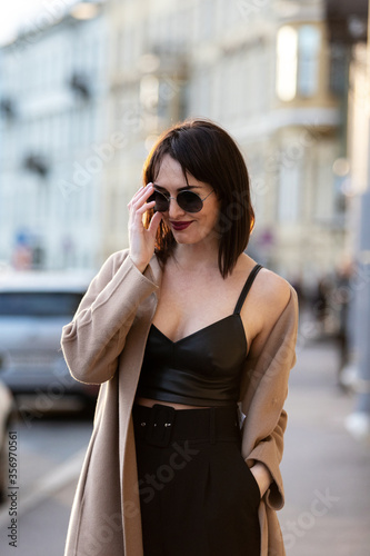 Woman in black pantsuit walks on promenade