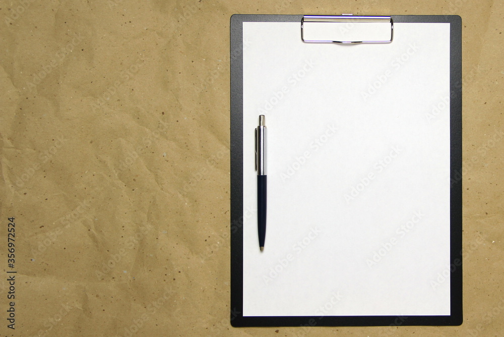 A tablet with a white sheet of A4 format on a beige craft paper. A tablet with a white sheet of A4 format on a beige craft paper.
