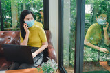 Asian women wear yellow shirts to work on holidays. Asian girl wearing mask, doctor sitting and working online During the outbreak of the Coronavirus infection or Covid 19.