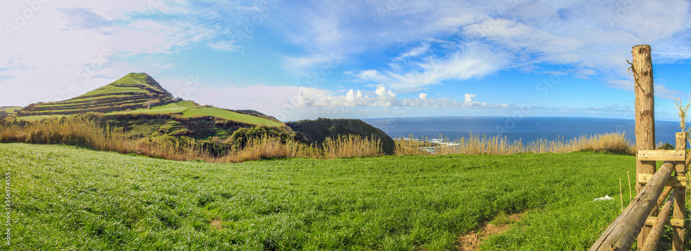 Panoramic view with meadow, sea and hill at the island of Sao Miguel, Azores islands, Portugal