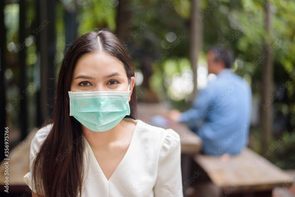 Beautiful woman is wearing face mask in coffee shop Beautiful woman is wearing face mask in coffee shop