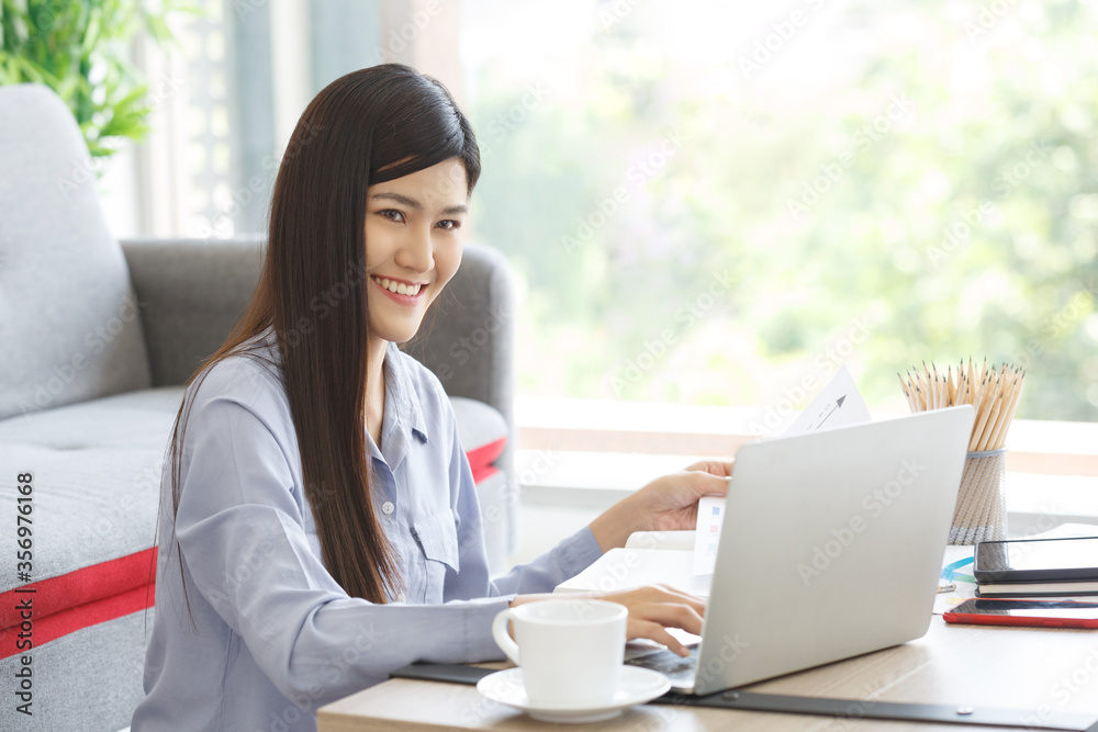 Young Cute Woman feels happy while working using Laptop on Work For Home Period. COVID-19 Lock Down. Copy Space. Young Cute Woman feels happy while working using Laptop on Work For Home Period. COVID-19 Lock Down. Copy Space.
