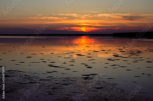 The salty  pink lake in the steppe at sunset is beautiful.