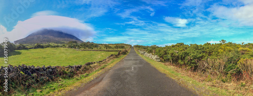 Panoramic view of Pico mountain with cloud formation and road at Pico island, Azores