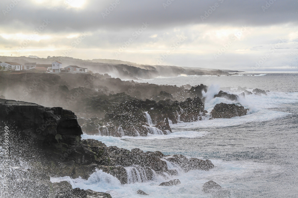 Wild seascape at Pico, Azores, Portugal, with black lava rocks on the coast