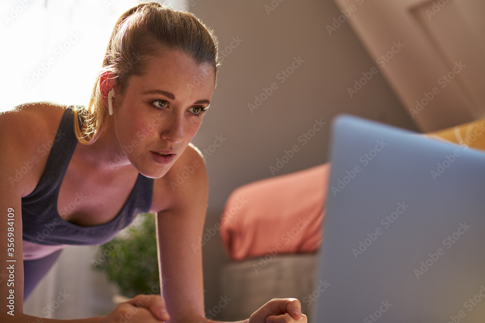 Young woman taking part in online fitness class