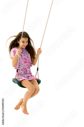 Beautiful teen school girl swinging on a swing. Concept summer vacation.