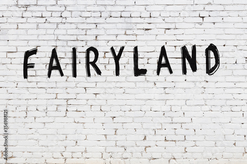 Photos White wall with black paint inscription fairyland on it