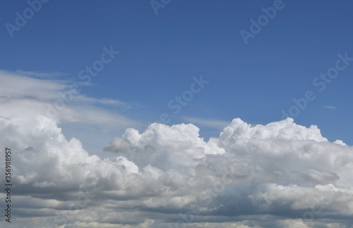 Aerial view on moody thunder clouds flying on horizon under blue sky