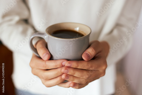 Female hands holding coffee mug