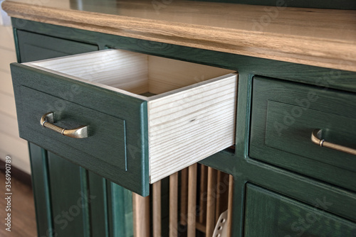 Fotografering Open drawer with copper handle of old vintage green and light brown wooden dress