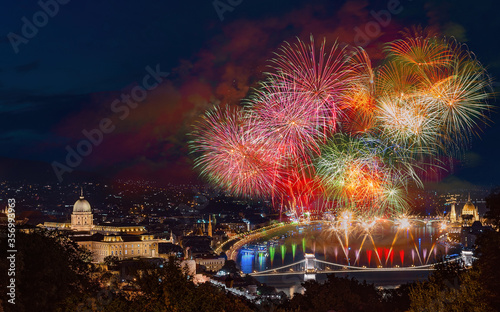 St Sephen memorial day in Budapest Hungary. Celebration fireworks over Danube river. Famous historical Buda castle on the left side Chain bridge on bottom and Hungarian parliament on right.