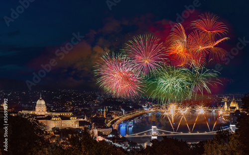 St Sephen memorial day in Budapest Hungary. Celebration fireworks over Danube river. Famous historical Buda castle on the left side  Chain bridge on bottom and Hungarian parliament on  right.