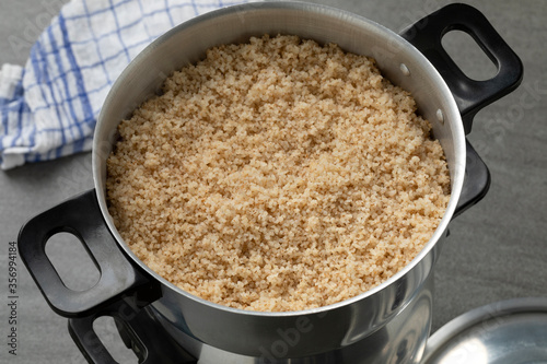 Steamed barley grits in a traditional aluminum food steamer close up photo