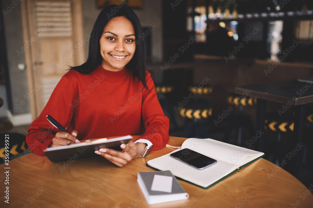 Afro american hipster girl dressed in red sweatshirt checking email Afro american hipster girl dressed in red sweatshirt checking email