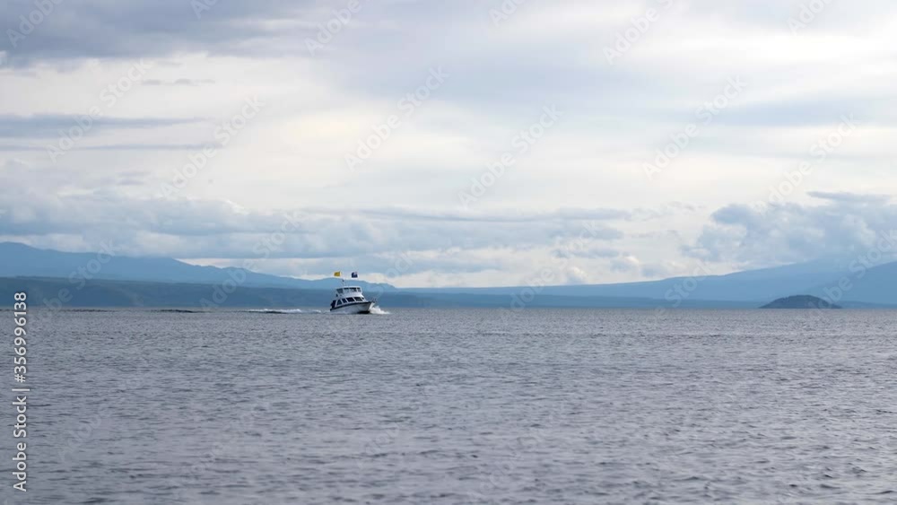 Beautiful landscape shot of a large boat cruising across Lake Taupo in New Zealand. Beautiful landscape shot of a large boat cruising across Lake Taupo in New Zealand.