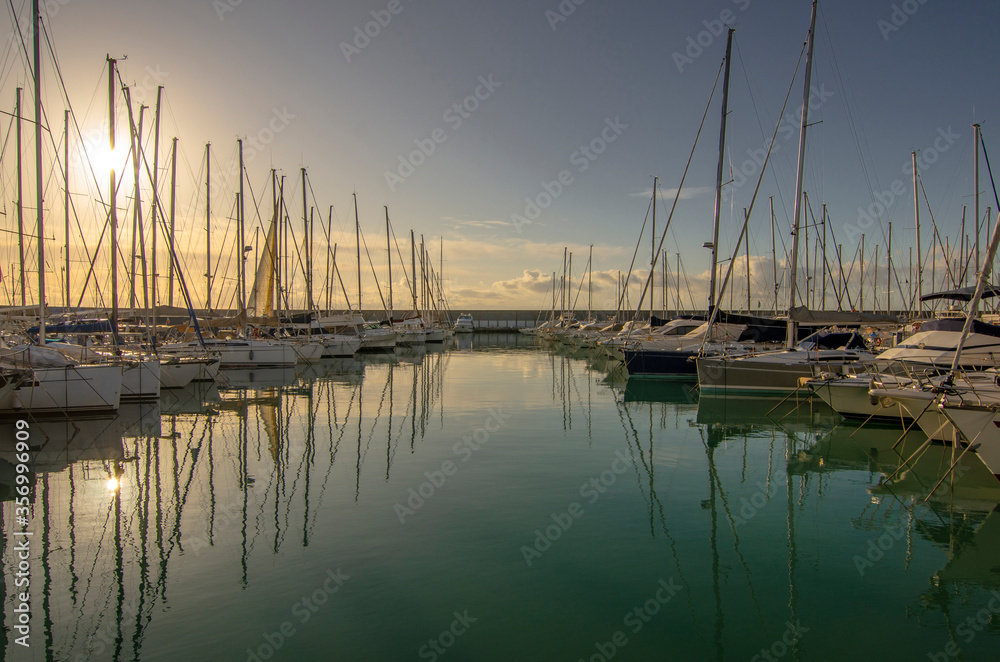 Small port with boats and reflections at sunset