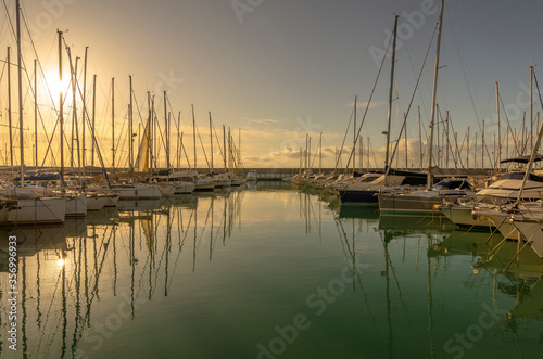 Small port with boats and reflections at sunset © giadophoto