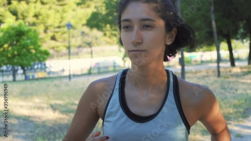 Young woman running in the park reflections of sun on her face