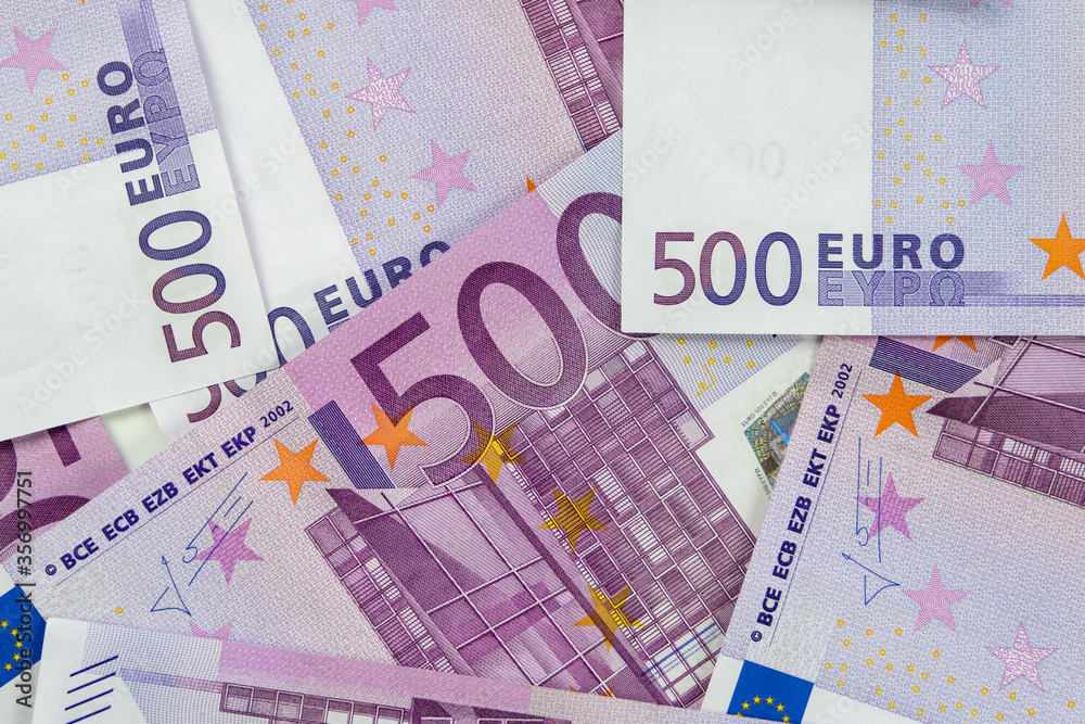 Banknotes of five hundred and 500 euros are scattered in a chaotic manner. European currency lies on the table. Blank for design, background. View from above. Banknotes of five hundred and 500 euros are scattered in a chaotic manner. European currency lies on the table. Blank for design, background. View from above.