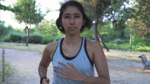 Front shot of a young woman running in the park
