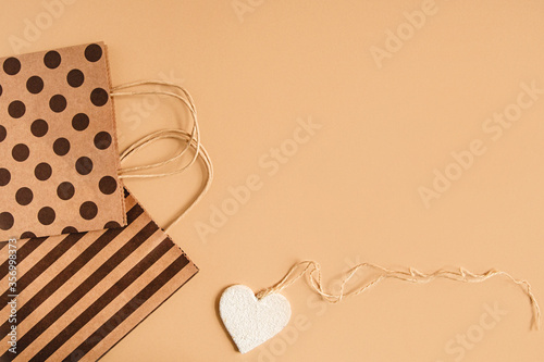 packaging bags with handles polka dot and stripe and a heart-shaped figure on a craft background. Flat layout with copyspace photo