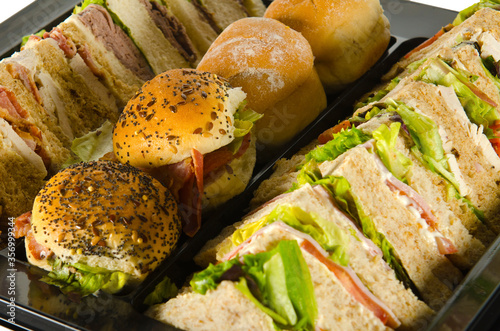 a plate of party food, wraps rolls and sandwiches photo