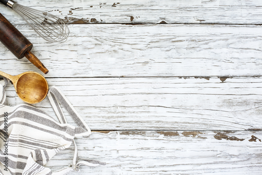 White wood baking supplies background with old wooden spoon, apron and ...