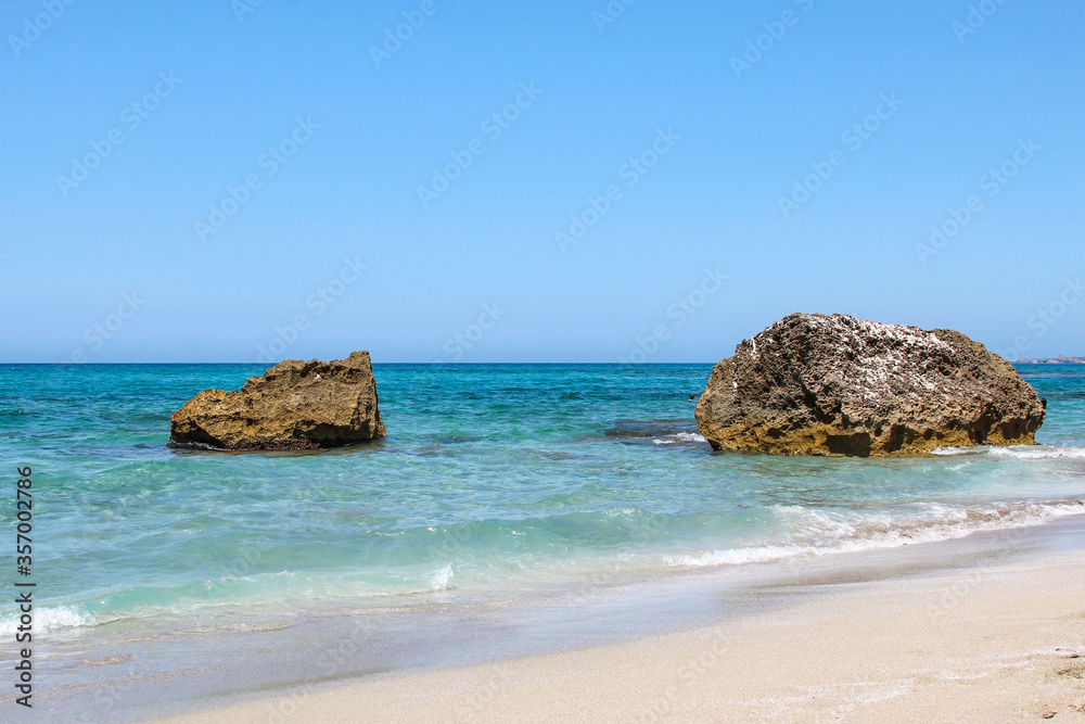 Coast with big stones and waves as a background. Blue water seascape.