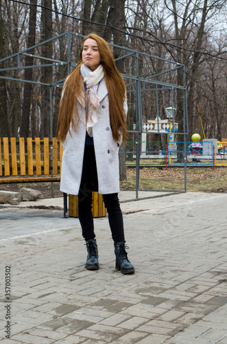 The girl is walking in the park. Read a book.
