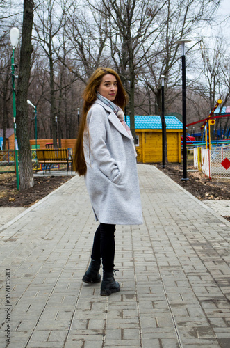The girl is walking in the park. Read a book.