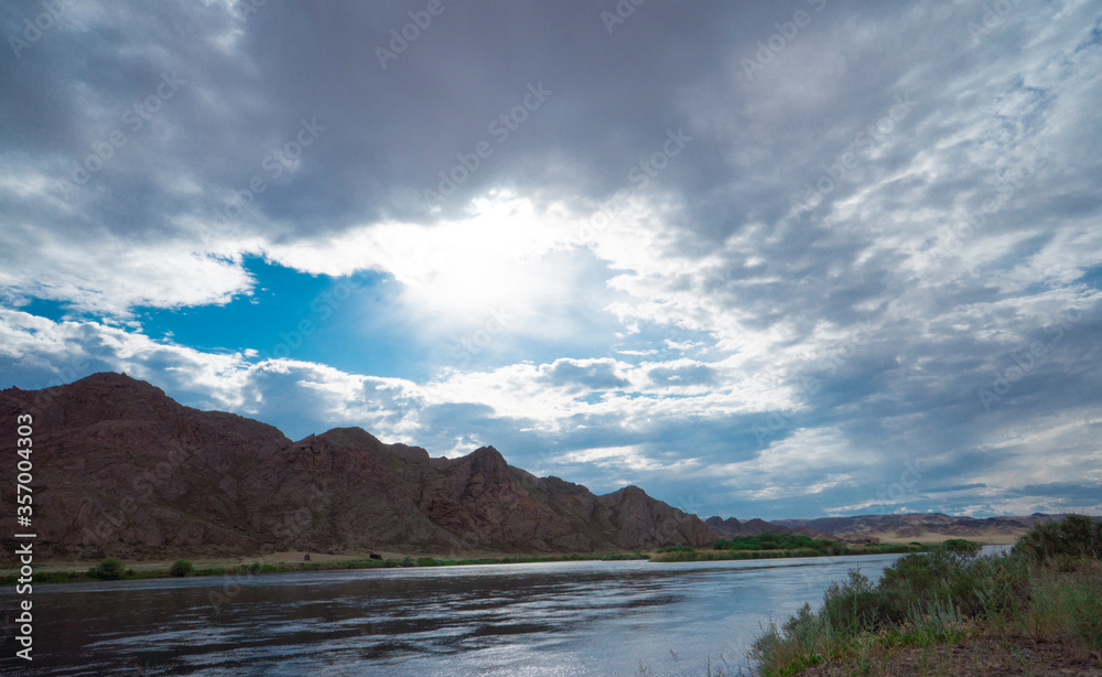 Sunset in the steppe in a river valley. Beautiful sunset. Landscape in the steppe, Prairie. Landscape in the evening. The clouds.