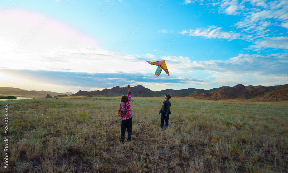 Children fly a kite in nature. Landscape in the steppe. Children fly a kite in nature. Landscape in the steppe.