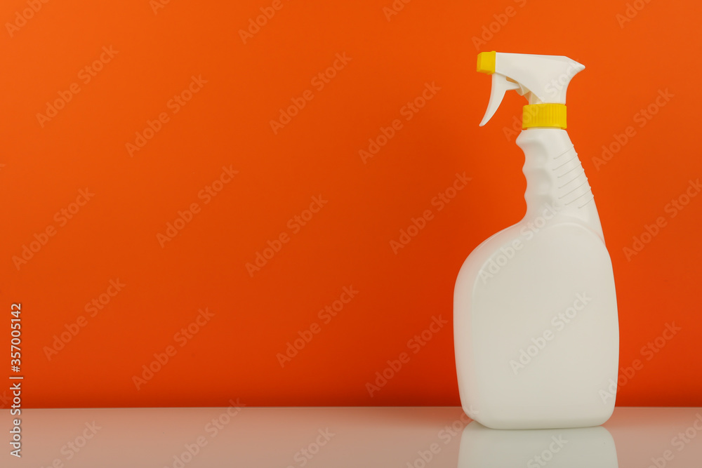 cleaning product in spray bottle on orange background with copy space cleaning product in spray bottle on orange background with copy space