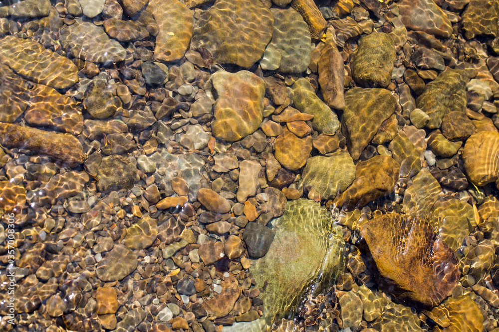 Kamienie rzeczne  rzeki Skawa obmywane jej wodami w promieniach słońca.