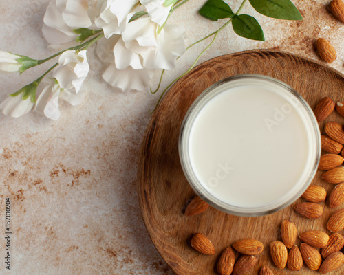 Organic almond milk, almonds on a brown background. Alternative to dairy products, milk for vegetarians. Copy space.