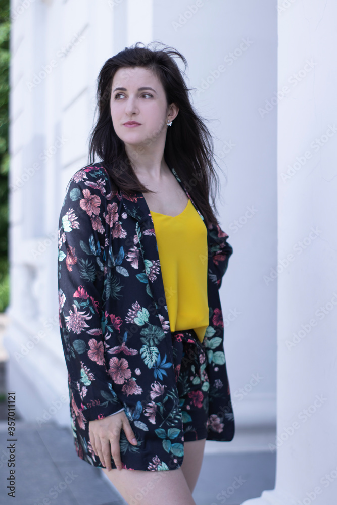 Attractive young brunette woman in yellow t-shirt and flowery shorts costume. copy space. High quality photo Attractive young brunette woman in yellow t-shirt and flowery shorts costume. copy space. High quality photo