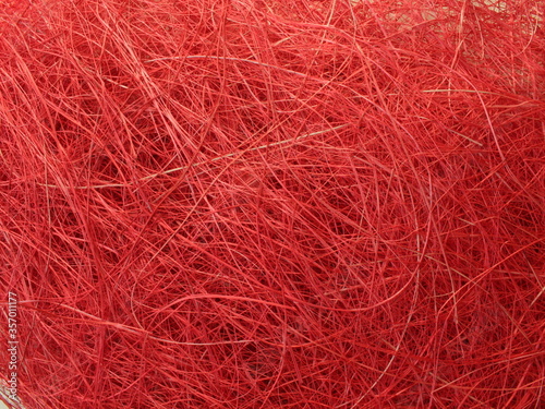 Abstract image texture is red with a chaotic mesh of thread. Christmas background.
