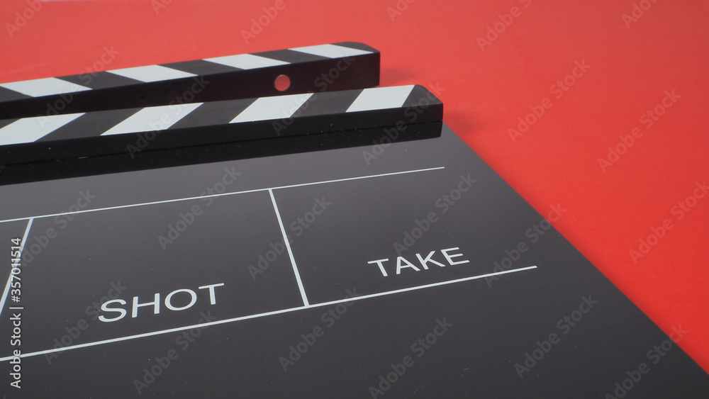 black Clapperboard or movie slate. it use in video production or film and cinema industry on red background.