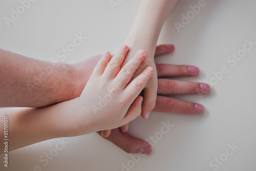 Hands of the father and son and daughter.