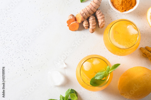 Jamu Indonesian herbal beverage with natural ingredients turmeric, ginger on white background. Space for text. View from above.