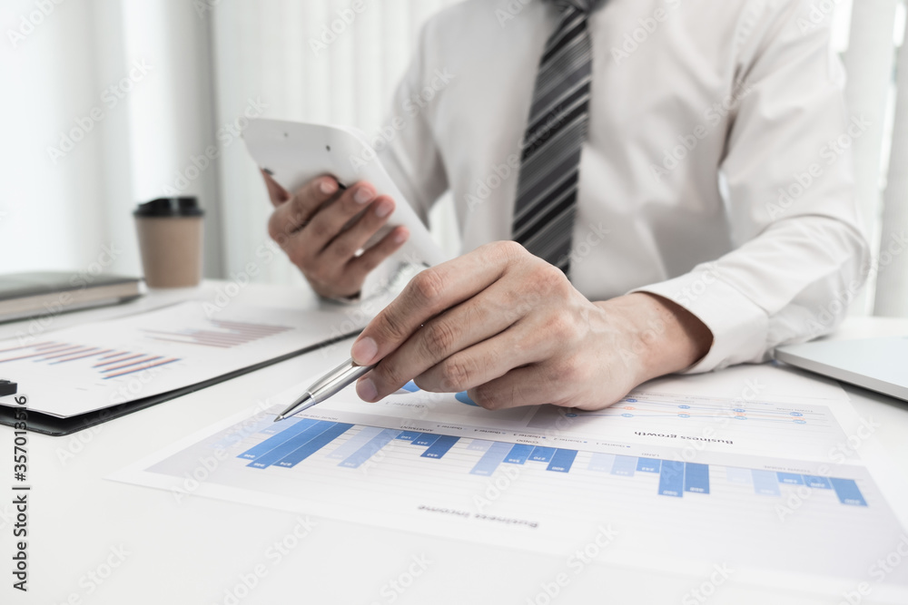 Businessman is analyzing business income with graph for planning strategy. Businessman is analyzing business income with graph for planning strategy.