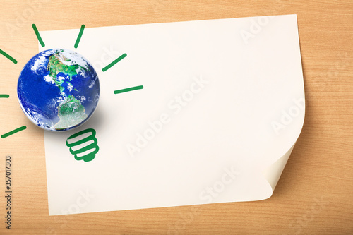 Earth and light bulb shape on white pager on wood table background, fill your green ideas on the blank paper for a better World concept, Elements of this image furnished by NASA photo